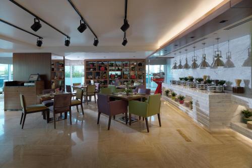 a restaurant with tables and chairs in a room at DAMAC Maison Canal Views in Dubai