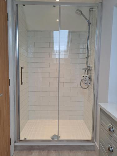 a shower with a glass door in a bathroom at Nanny lane loft in Church Fenton