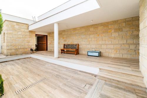 an empty patio with a bench and a brick wall at Goudi Residence in Goudhi