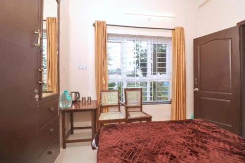 a bedroom with a bed and a desk and a window at HIGHLAND Hills in Coonoor