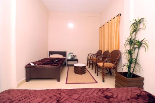 a bedroom with a bed and chairs and a table at HIGHLAND Hills in Coonoor