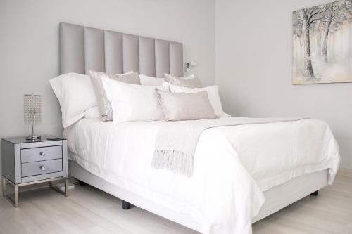 a white bed with white sheets and pillows at Augusta Palms in Centurion