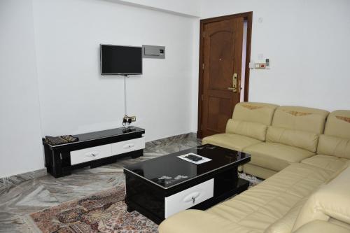 a living room with a couch and a table at Royal Suite Hotel Apartments in Al Ḩuwayl