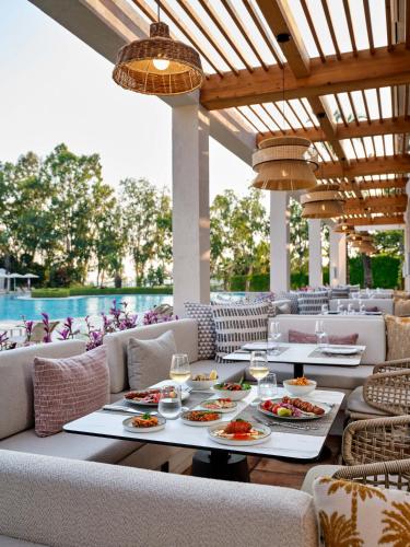 a restaurant with tables and chairs with food on them at Paloma Grida in Belek
