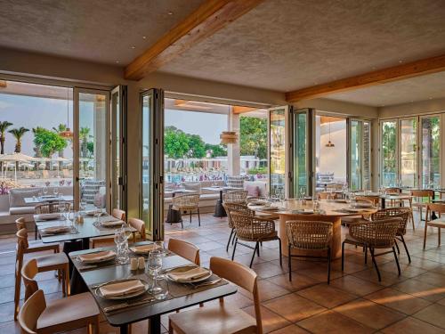a restaurant with tables and chairs and windows at Paloma Grida in Belek