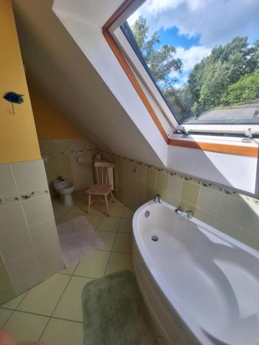 a bathroom with a large window and a bath tub at Gospodarstwo Agroturystyczne Bukowy Jar in Połczyn-Zdrój