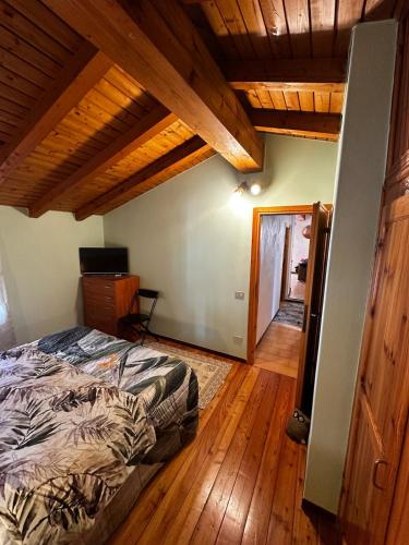 a bedroom with a bed and a wooden floor at Baita in città in Branzi