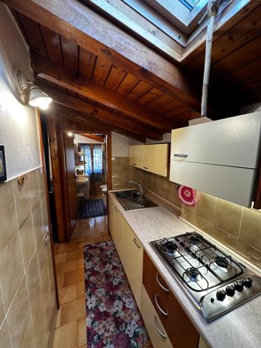 a kitchen with a stove and a counter top at Baita in città in Branzi