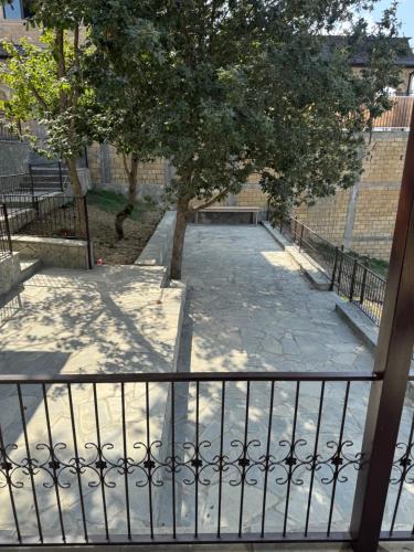 a walkway with a tree and a fence at Трехкомнатный дом в Пиргулу in Avaxıl