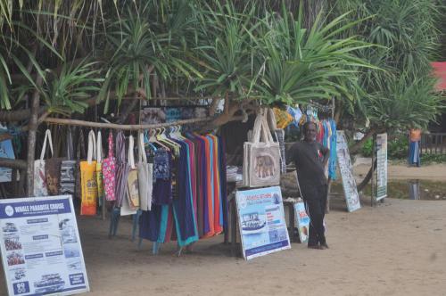 a man standing in front of a clothing stand at Talalla Bay Inn Beach Bungalow in Talalla