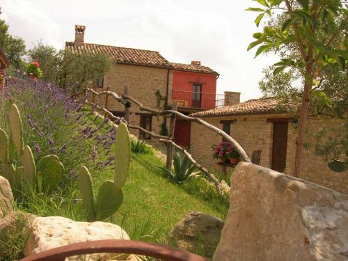 a garden with purple flowers and a house at Gorgeous Apartment with Pool near Sibillini Mountains in Monte San Martino