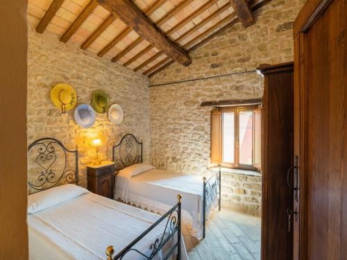 a bedroom with two beds in a stone building at Gorgeous Apartment with Pool near Sibillini Mountains in Monte San Martino