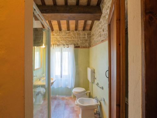 a bathroom with a toilet and a glass shower at Gorgeous Apartment with Pool near Sibillini Mountains in Monte San Martino