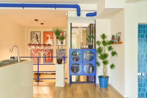 a room with a blue cabinet with plants in it at 5loft Anti-Hotel, Silom, Bangkok in Bangkok