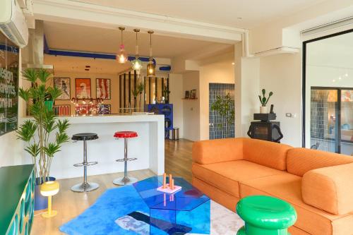 a living room with an orange couch and a bar at 5loft Anti-Hotel, Silom, Bangkok in Bangkok