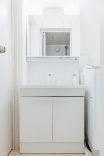 a white kitchen with a sink and a mirror at Geisha Blue Ryusenji in Kasugai