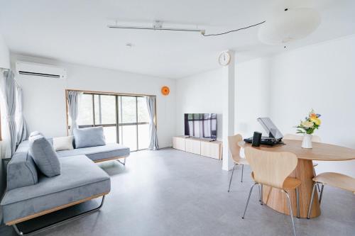 a living room with a couch and a table at Geisha Blue Ryusenji in Kasugai