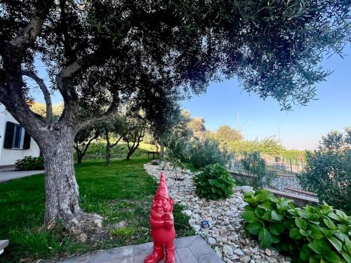 a red fire hydrant sitting next to a tree at Casa Piro in Magliolo
