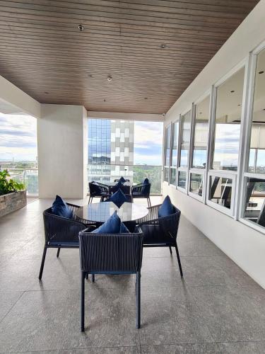 a dining room with a table and chairs and windows at JND Residences - Sitari in Bacolod