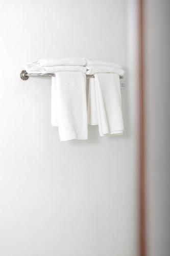 a group of white towels hanging on a towel rack at Roshanne Beach Resort in Kalpitiya