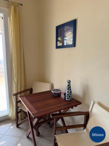 a dining room with a wooden table and chairs at Theasea Suites - Ateliou in Vari