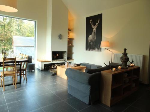 a living room with a blue couch and a table at Gite with swimming pool situated in wonderful castle grounds in Gesves in Gesves