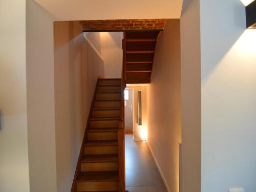 a wooden staircase in a house with a white wall at Gite with swimming pool situated in wonderful castle grounds in Gesves in Gesves