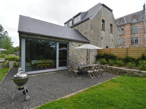a backyard with a grill and a table with chairs at Gite with swimming pool situated in wonderful castle grounds in Gesves in Gesves