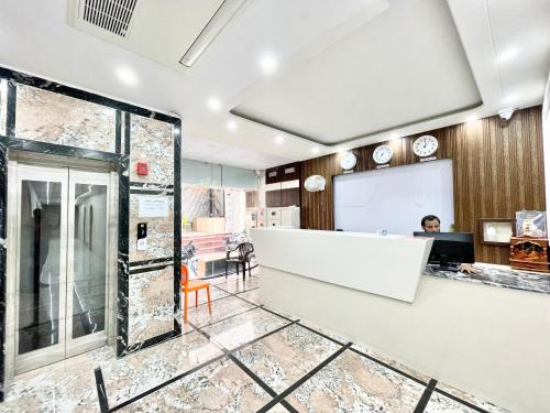 an office with a woman sitting at a desk at Hotel Premium LAXMIVILLAS ! Varanasi, Near Kashi Vishwanath Temple And Railway station, Fully Air conditioned & Spacious Room - Prime Location wifi- Lift and Room Service Facilities, BEST HOTEL IN VARANASI in Varanasi