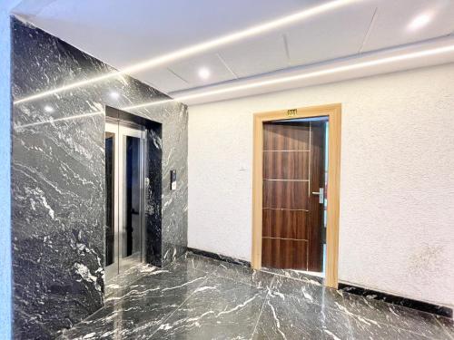 a hallway with black marble and a brown door at Hotel Premium LAXMIVILLAS ! Varanasi, Near Kashi Vishwanath Temple And Railway station, Fully Air conditioned & Spacious Room - Prime Location wifi- Lift and Room Service Facilities, BEST HOTEL IN VARANASI in Varanasi