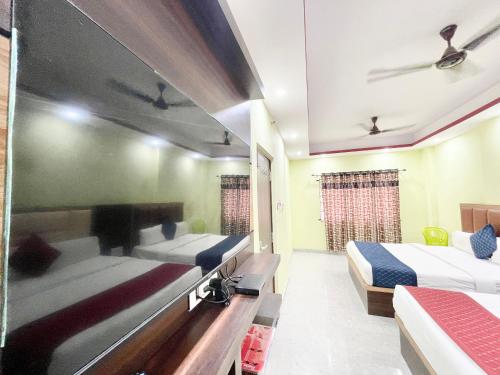 a hotel room with two beds and a mirror at Hotel Premium LAXMIVILLAS ! Varanasi, Near Kashi Vishwanath Temple And Railway station, Fully Air conditioned & Spacious Room - Prime Location wifi- Lift and Room Service Facilities, BEST HOTEL IN VARANASI in Varanasi