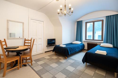 a hotel room with two beds and a table and a desk at Senate Hotel in Helsinki