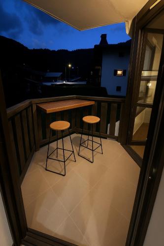 a balcony with a table and two stools on it at Appartement 1 Chambre in Les Houches