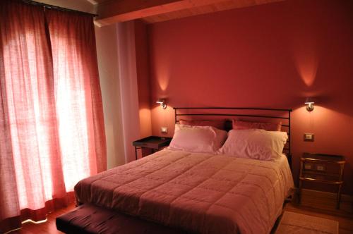a bedroom with a large bed with red walls at Agriturismo Trerè in Faenza