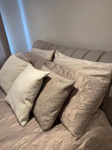 a bed with four pillows on top of it at Barnet newly renovated in Barnet