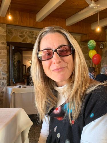 a woman wearing glasses sitting at a table at Lo Spazio dell'Anima 