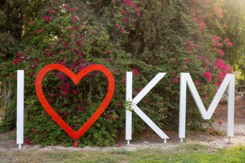 a heart sign in front of a bush with pink flowers at Kibbutz Kfar Masaryk Country Lodging in Kefar-Massariq