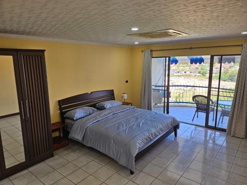 ein Schlafzimmer mit Bett und Balkon in der Unterkunft Villa Germania in Jomtien Beach