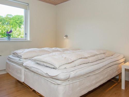 a white bed in a room with a window at 12 person holiday home in Aabenraa-By Traum in Loddenhøj