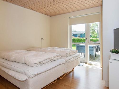 a bedroom with a bed and a sliding glass door at 12 person holiday home in Aabenraa-By Traum in Loddenhøj