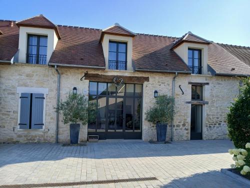 a large stone house with a black door at Lilau - Villa 4 personnes proche Chantilly in Gouvieux