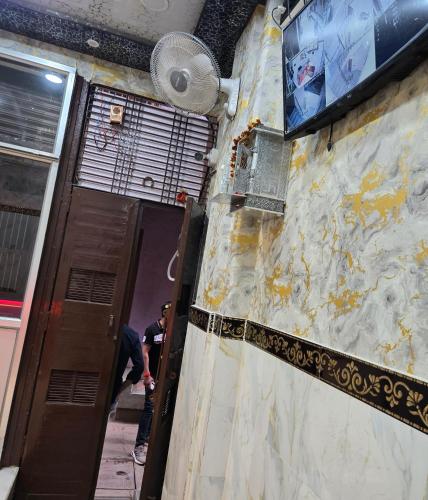 a stone wall with a door and a fan on it at Hotel Premium RUDRA GUEST HOUSE ! Varanasi, Near Kashi Vishwanath Temple And Ganga Ghat, Fully Air conditioned & Spacious Room - Prime Location BEST HOTEL IN VARANASI in Varanasi