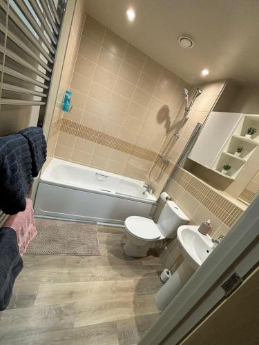 a bathroom with a tub and a toilet and a sink at Central, Close to Theatre & Cruise Port, with free parking space! in Southampton