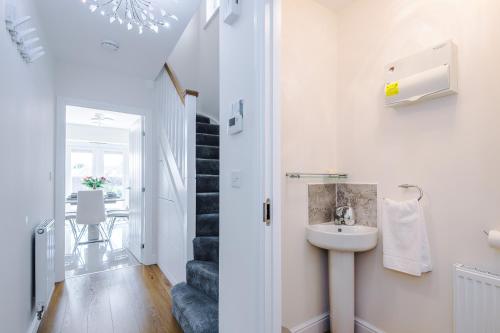 a bathroom with a sink and a staircase at Long Term Stay 4 Bed 3 Bath & Parking Wrexham in Wrexham