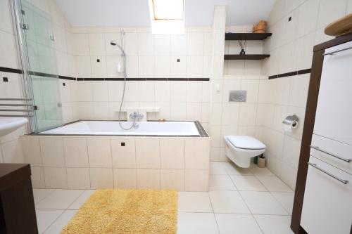 a white bathroom with a tub and a toilet at Dom pod Górskim Niebem in Kobiernice