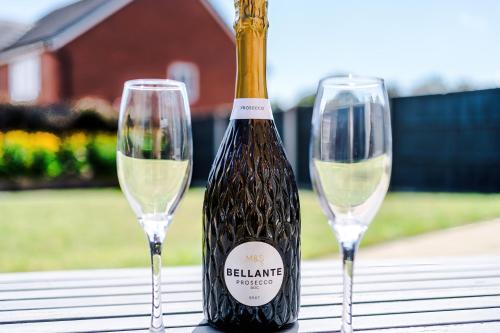 a bottle of wine and two glasses on a table at Long Term Stay 4 Bed 3 Bath & Parking Wrexham in Wrexham