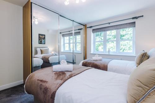 a bedroom with two beds and a mirror at Long Term Stay 4 Bed 3 Bath & Parking Wrexham in Wrexham