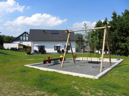 a playground with a swing set in a yard at Moderne Villa in Medebach Küstelberg in Medebach