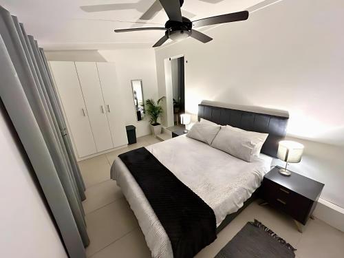 a bedroom with a bed and a ceiling fan at Flat 2 on 8 Lindsay in Ballito