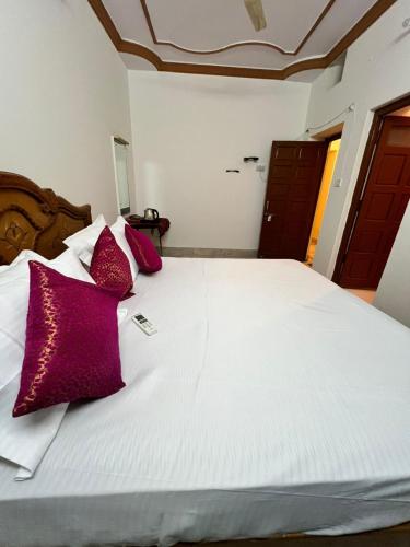 a bed with red and purple pillows on it at Golden villa in Jaisalmer